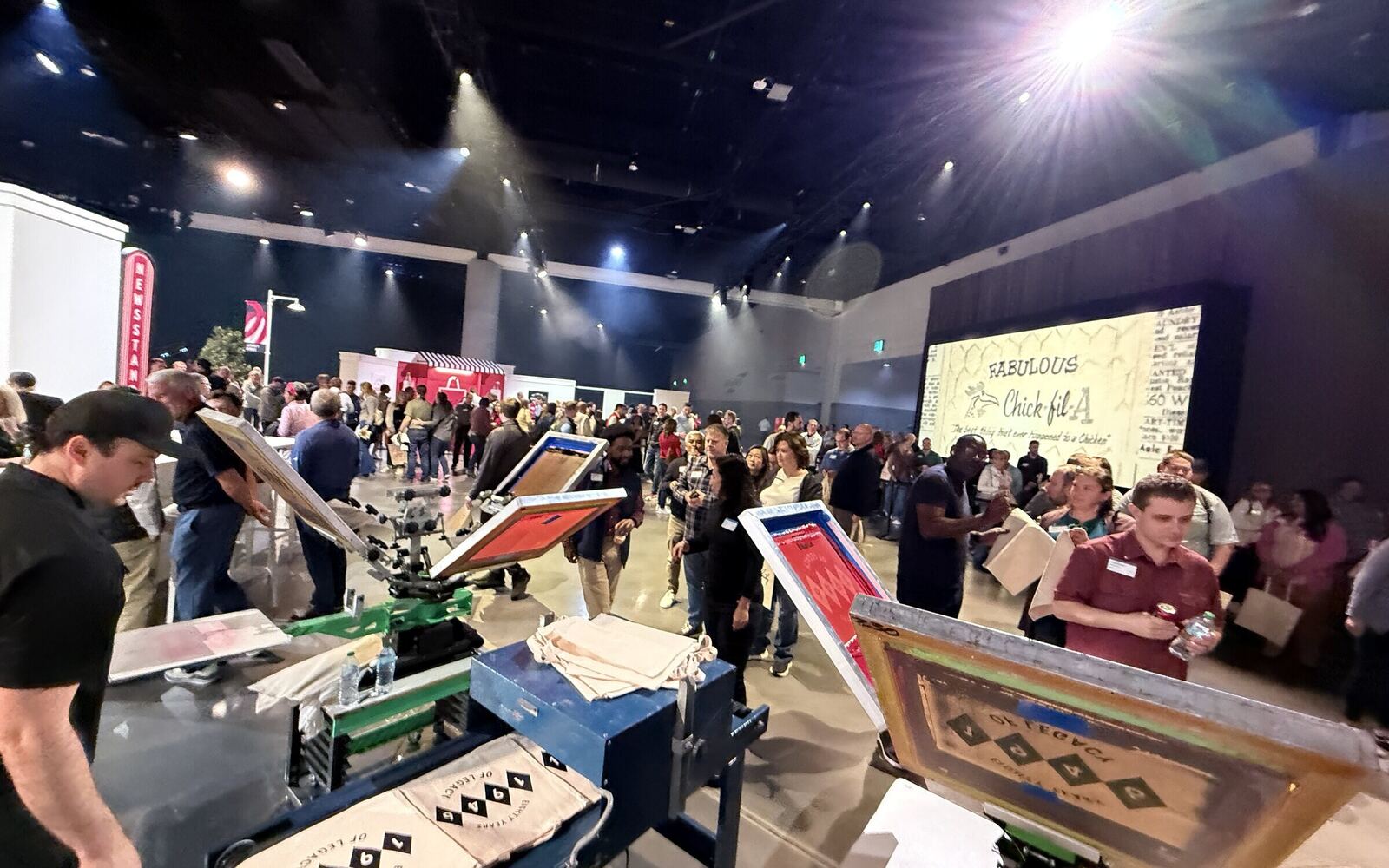 Employees lined up around live printing stations at a corporate event